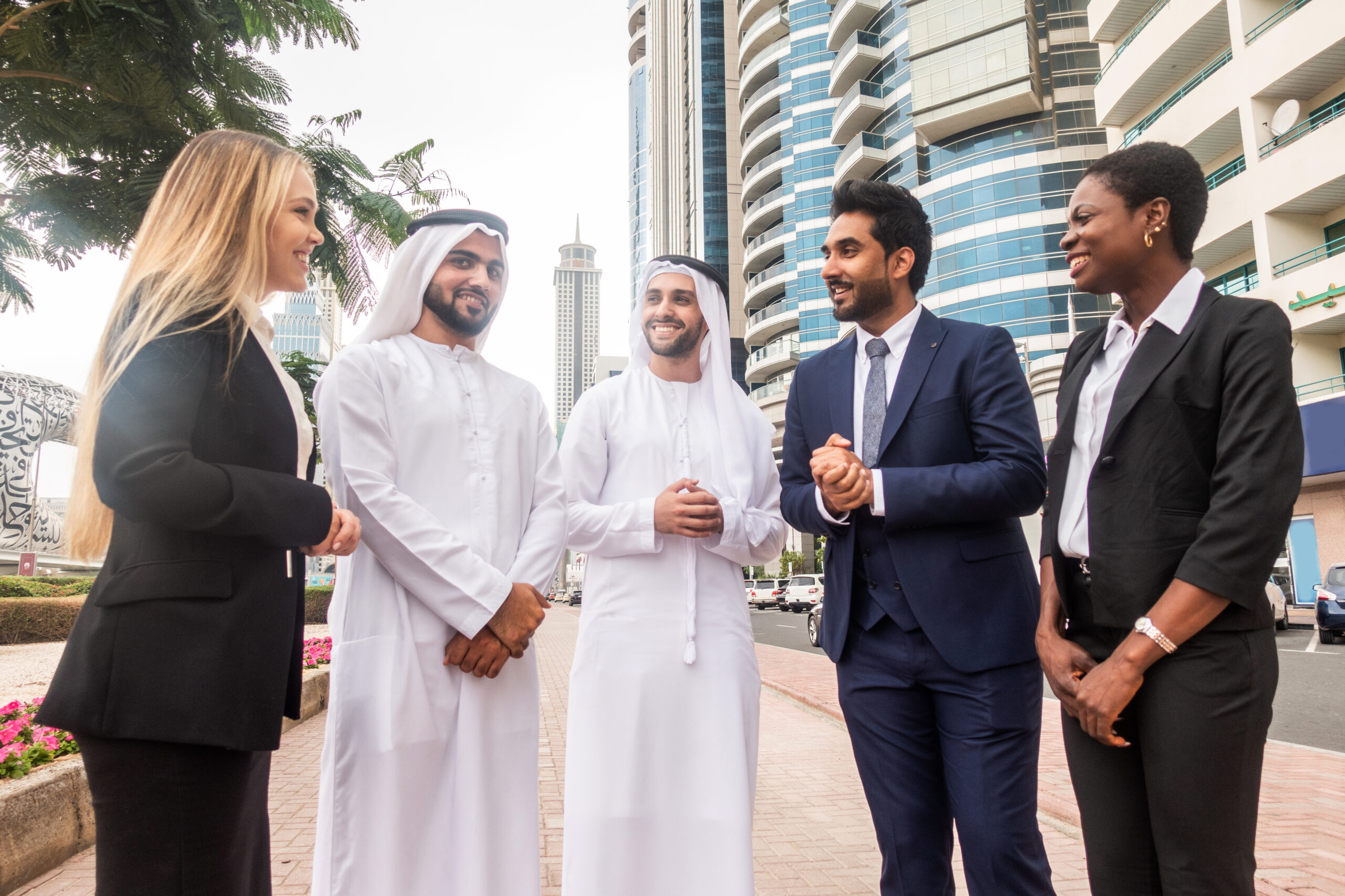Multi-ethnic group of people on a business meeting in the UAE - Business people walking outdoors and talking about business